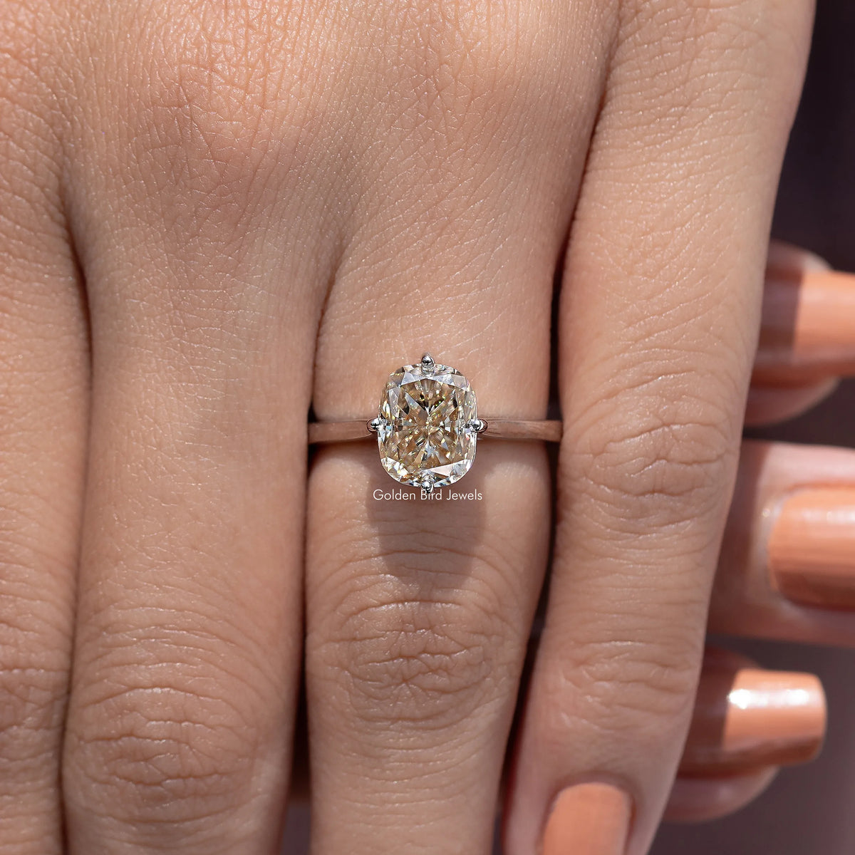 Rose-gold tone elongated cushion-cut solitaire engagement ring with four-prong setting