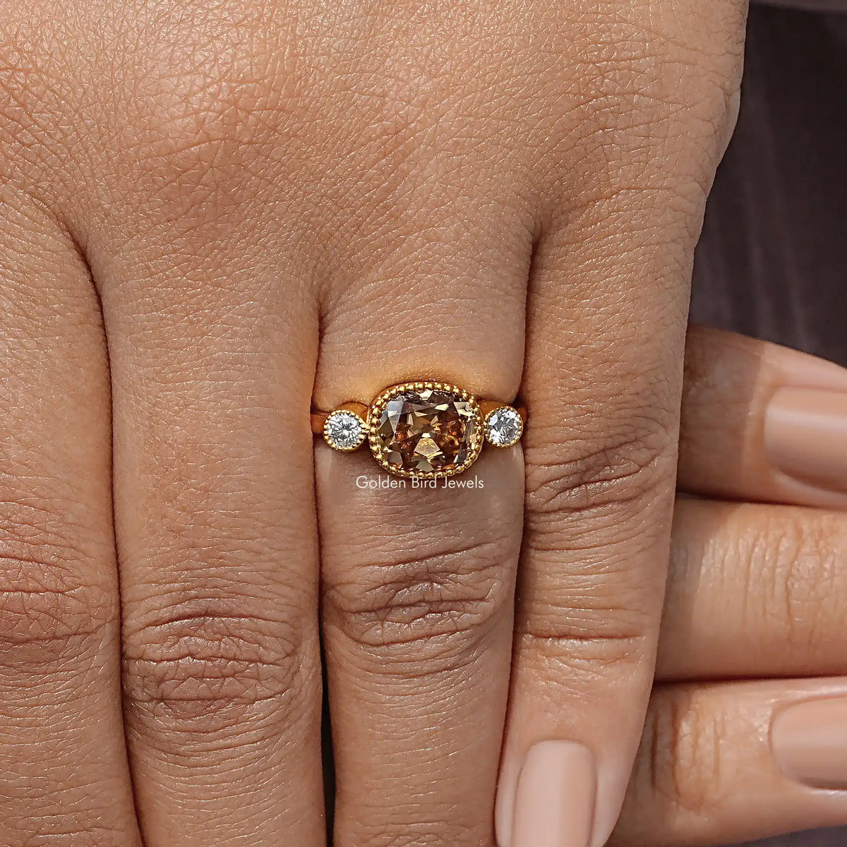 Yellow gold three-stone ring with cushion-cut center and two round side stones