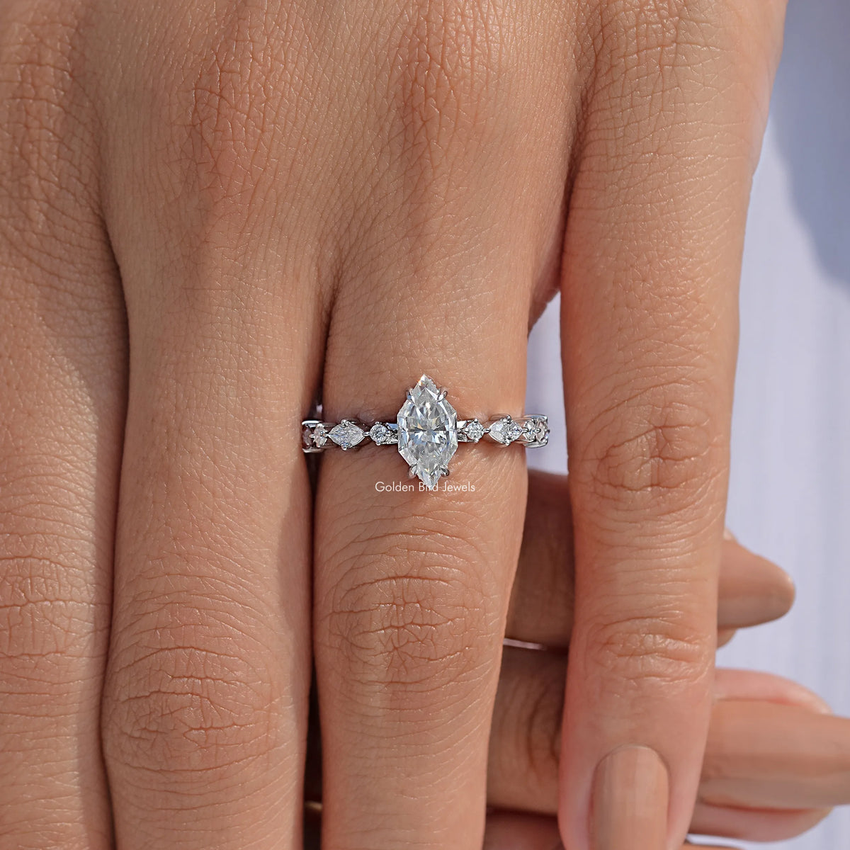 Close-up sterling silver marquise moissanite ring with central elongated stone and side stones