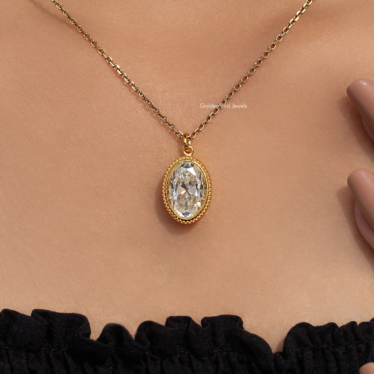 Gold-tone oval bezel pendant with white old mine-cut stone on chain