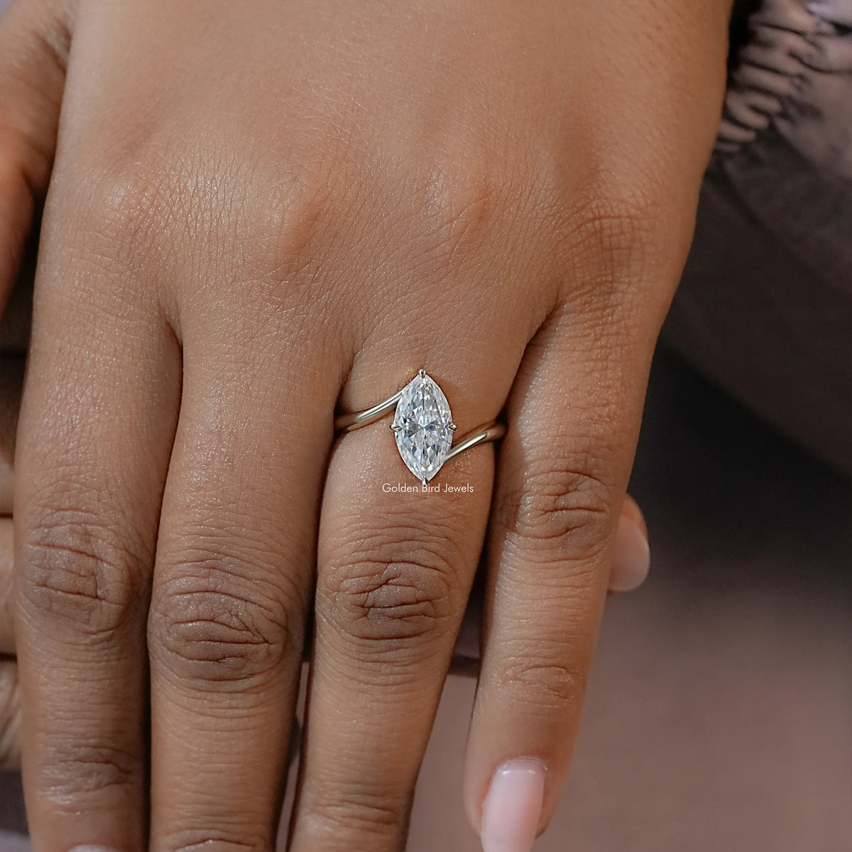 Marquise moissanite solitaire engagement ring on hand with marquise center stone