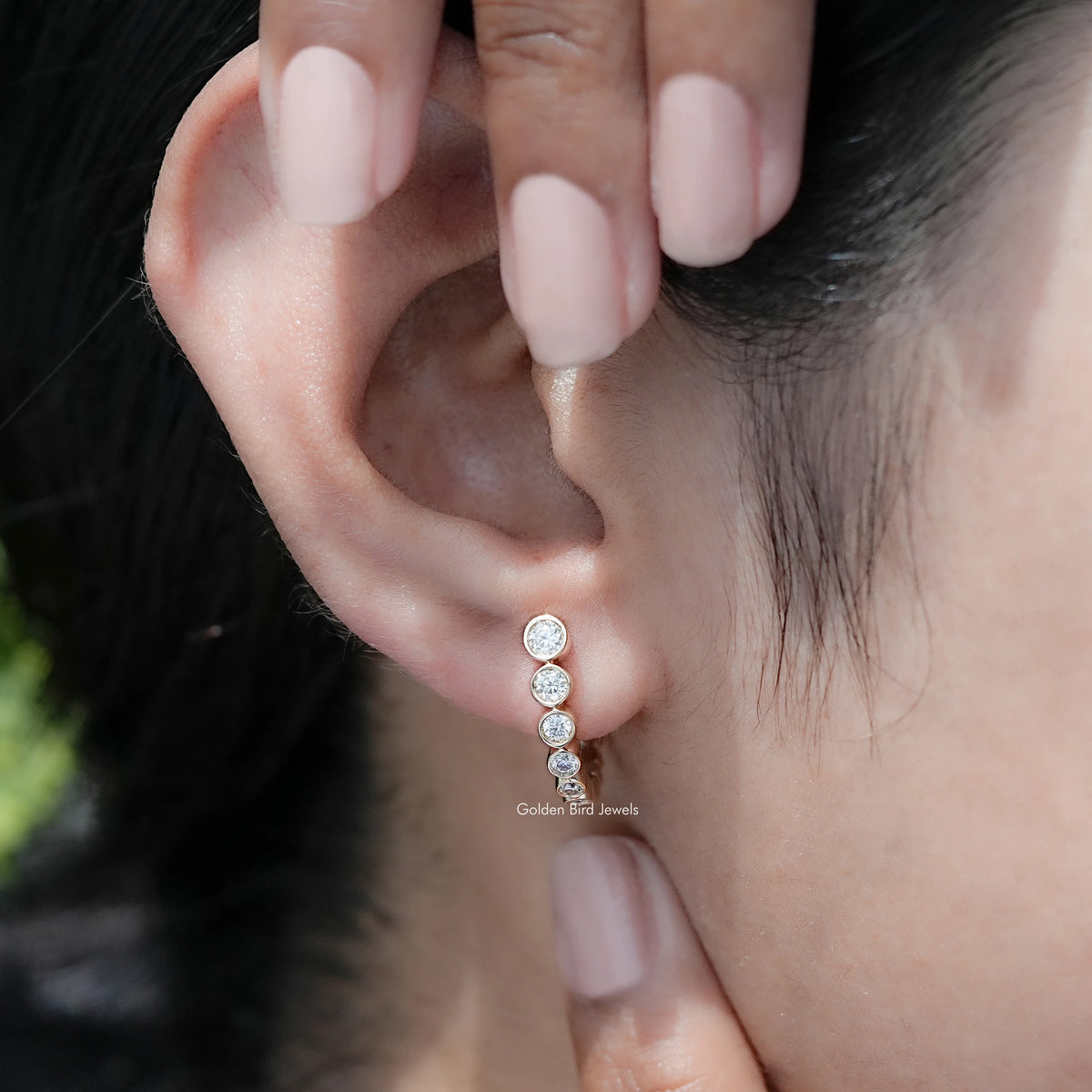 Detailed View Of Round Cut Moissanite Graduated C Hoop Earrings in secure setting