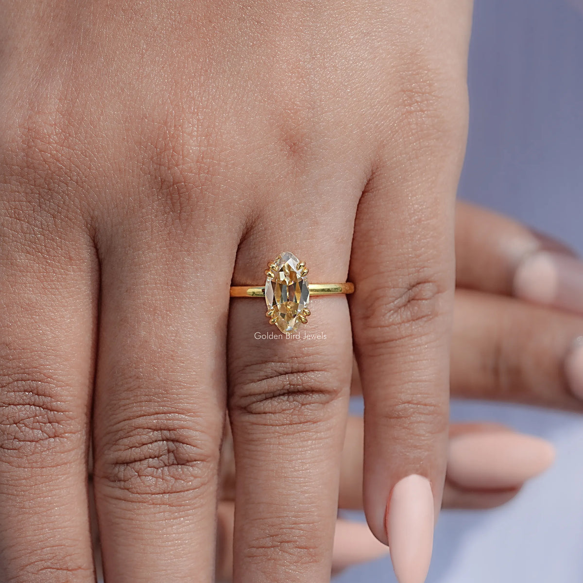 Gold solitaire ring with oval center moissanite and thin band, four prongs