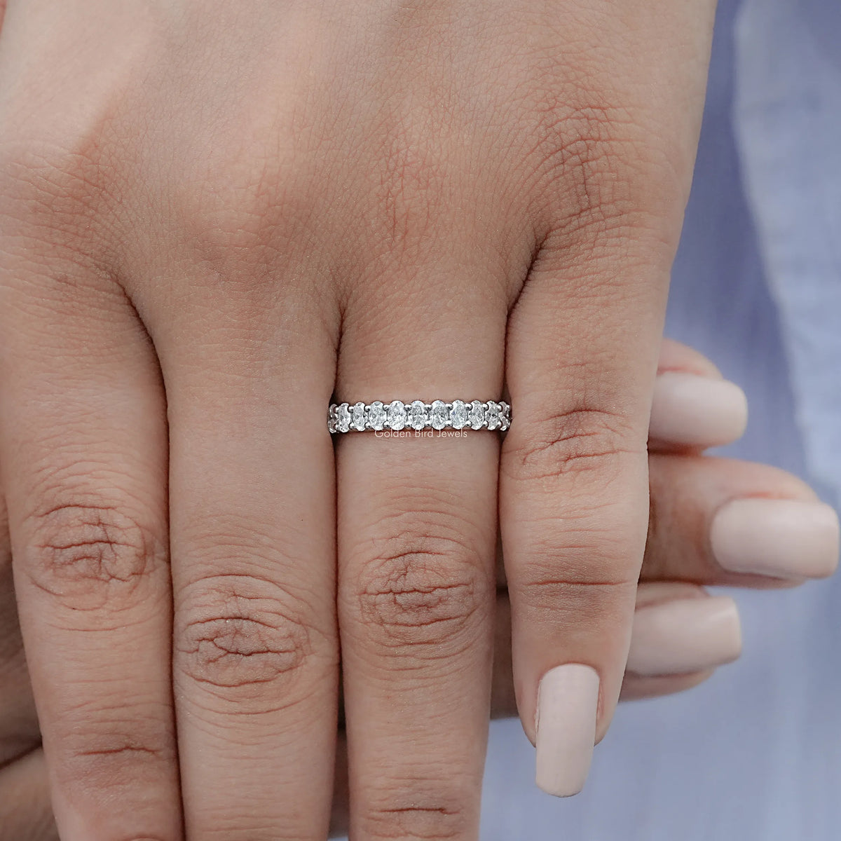Sterling silver half-eternity ring with oval moissanite stones across the band