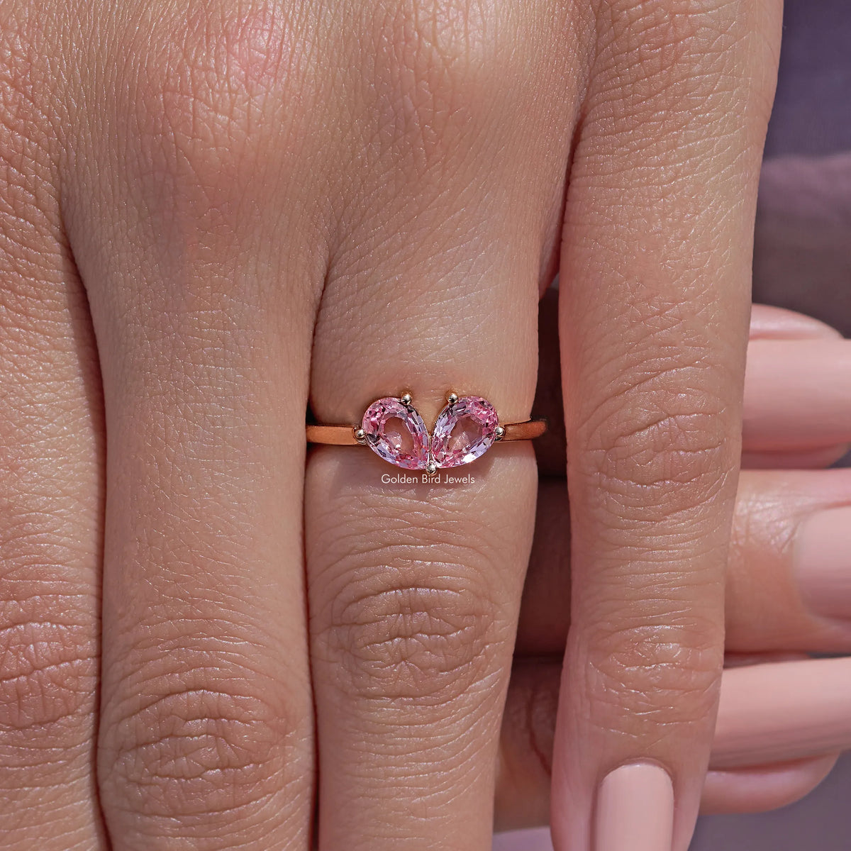 Pink pear-cut lab gemstone toi et moi ring with two prong-set stones on slim band