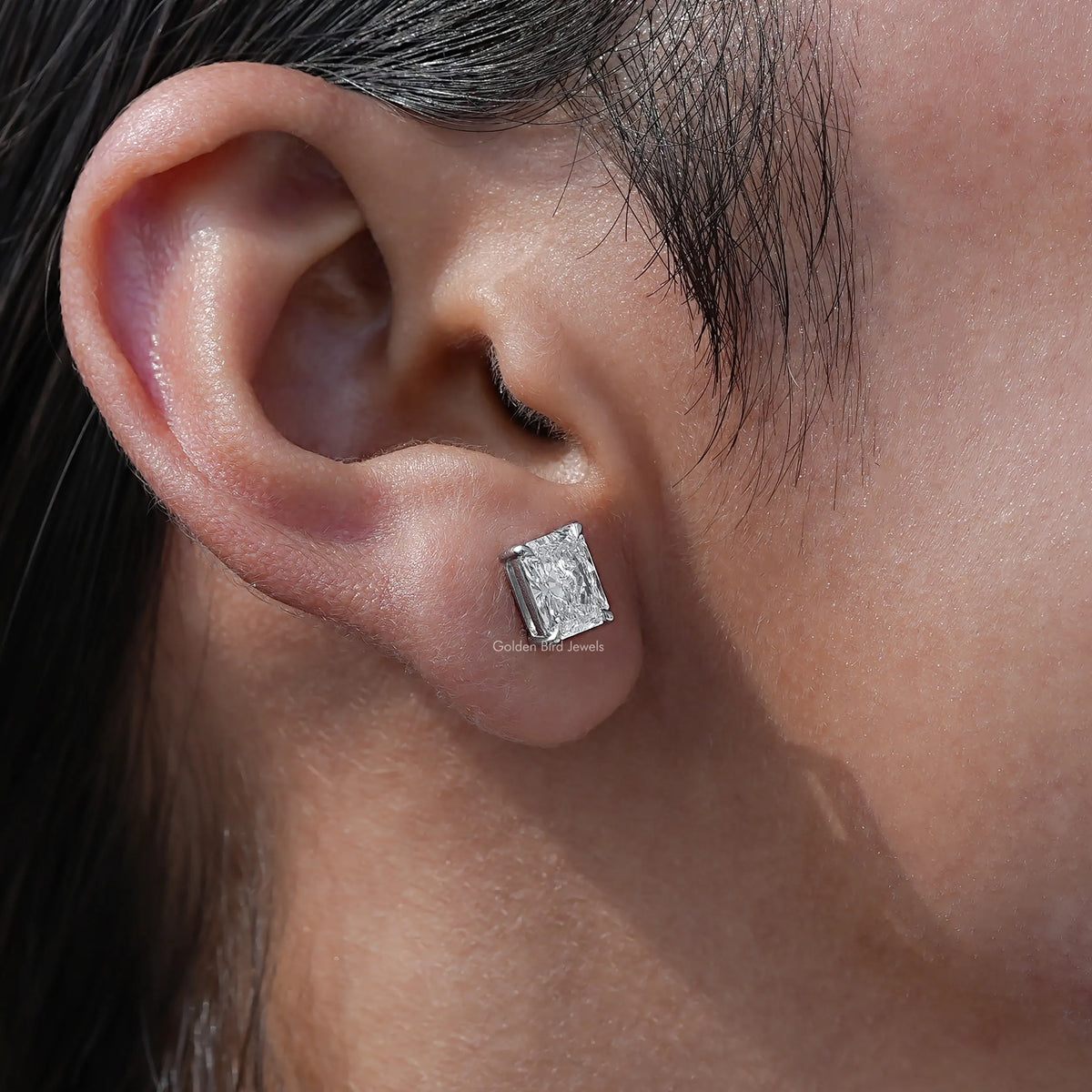 Detailed view of radiant cut diamond stud earrings in secure setting