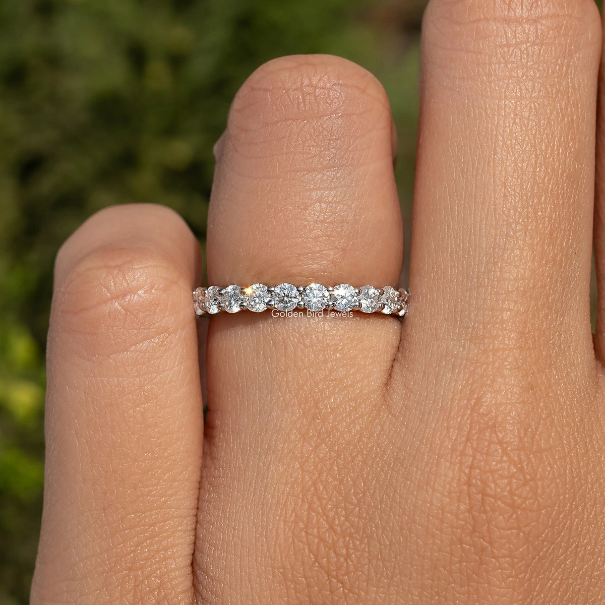 Three-quarter moissanite eternity band on hand, round stones set across the top