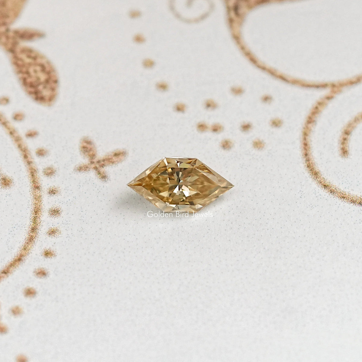 Marquise-cut golden moissanite gemstone with pointed ends and faceted sparkle