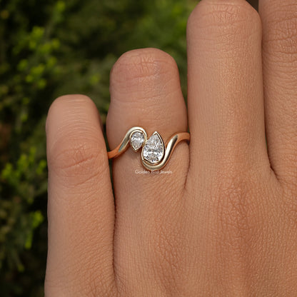 Rose gold toi et moi ring with two pear-cut lab diamonds, close on finger