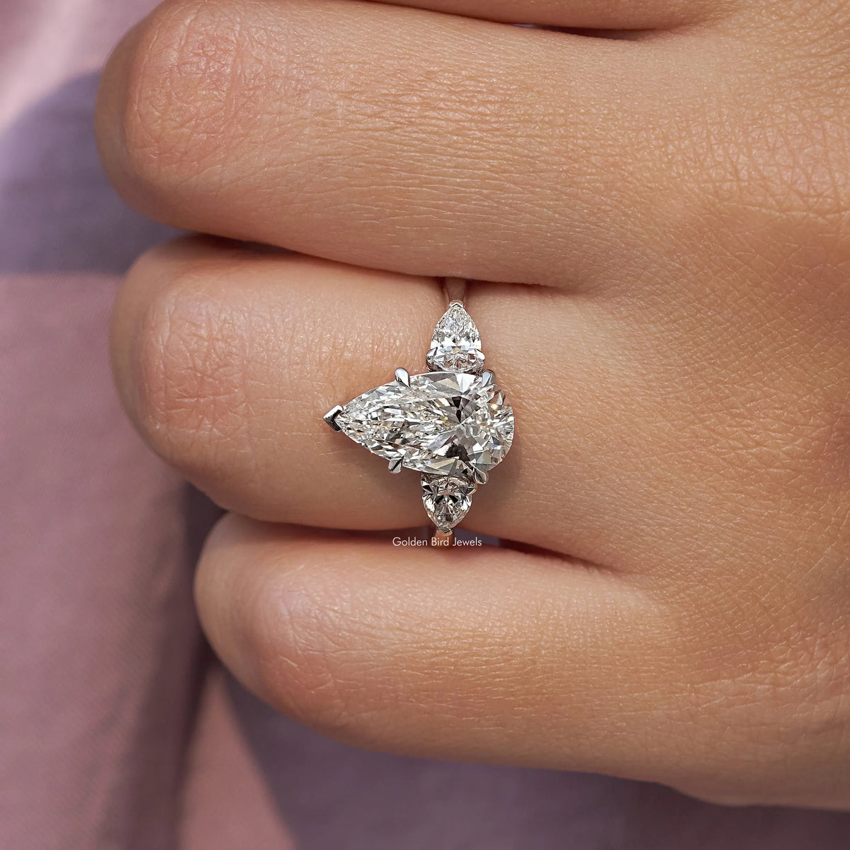 Three-stone pear-cut diamond engagement ring, close-up of center pear and side stones
