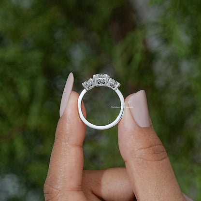 Three-stone moissanite ring top view showing round prong-set center stone