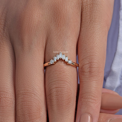 Curved wedding band ring with baguette-cut stones and small round side accents on finger