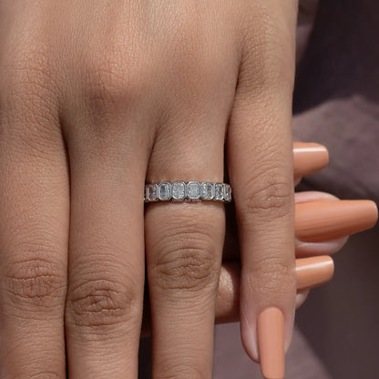 Silver eternity band ring with rectangular bezel-set stones, close-up on hand