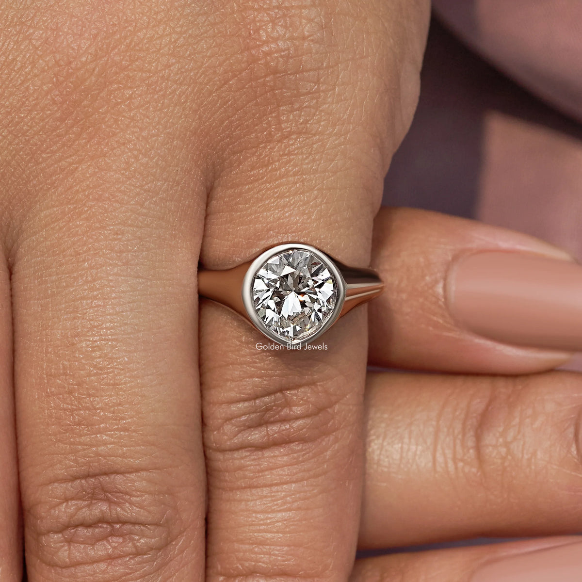 Silver bezel-set diamond engagement ring, angled side view on finger