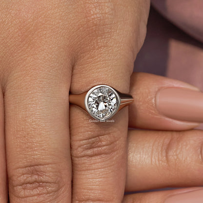 Silver bezel-set diamond engagement ring, angled side view on finger
