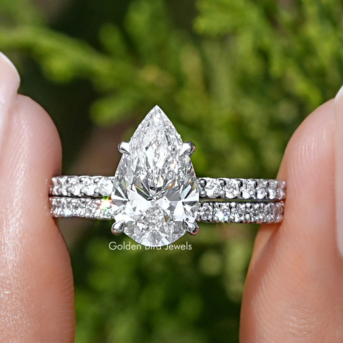 Pear-shaped diamond ring with sparkling side stones on a silver band