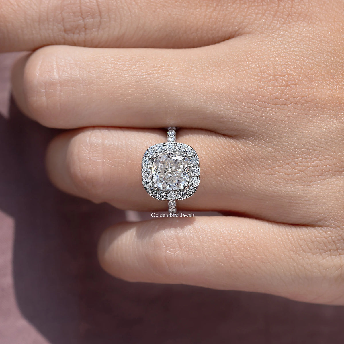 Silver-tone cushion-cut halo ring with bezel-like frame and four side prongs
