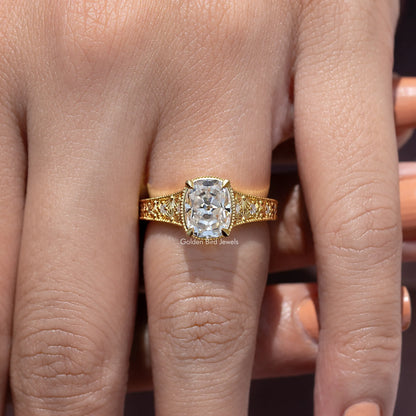 Gold cushion-cut moissanite ring with halo, filigree shoulders, and ornate prongs