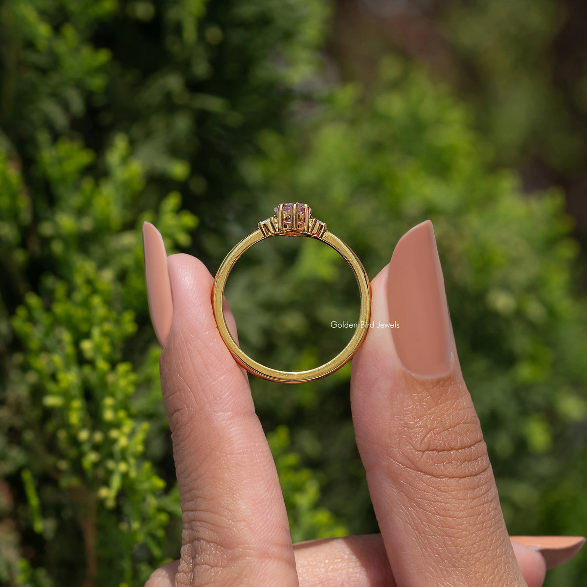 Gold ring band with pink kite-cut gemstone top view and prong setting