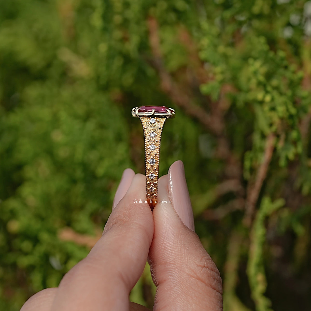 Gold engagement ring with cushion-cut purple center stone and studded band