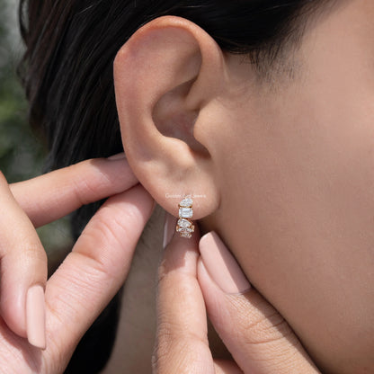 Gold-tone huggie hoop earrings with multi-shaped lab diamonds, hand adjusting on ear