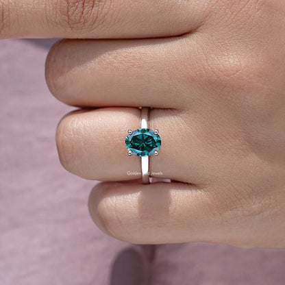 Oval teal moissanite center stone ring with hidden halo, close-up on hand