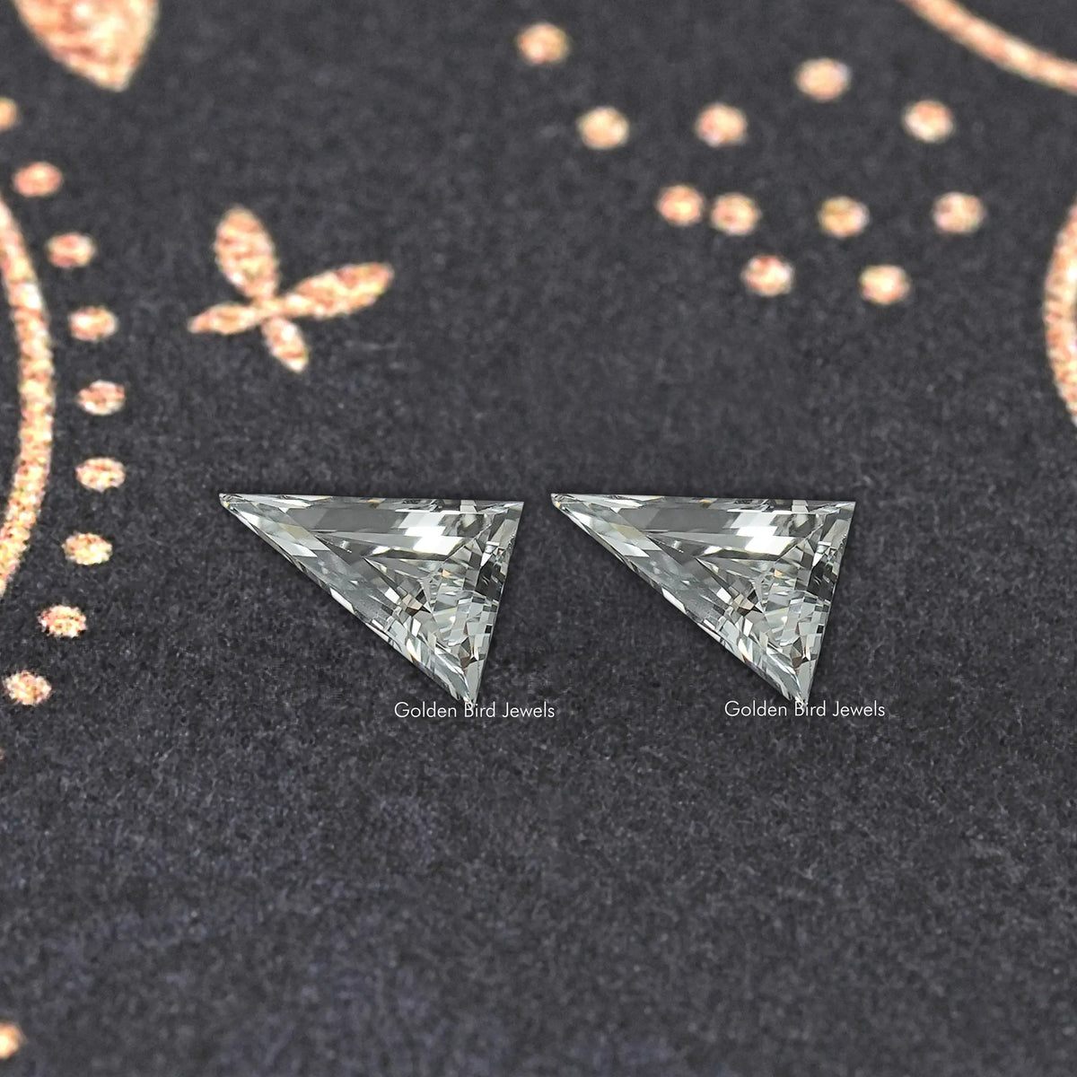 Long triangle lab-cut diamond studs, close-up of two faceted triangular gems