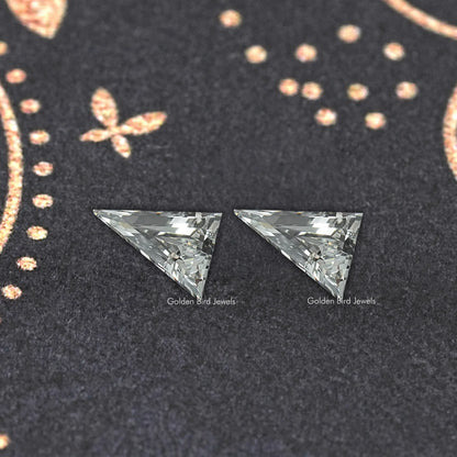 Long triangle lab-cut diamond studs, close-up of two faceted triangular gems