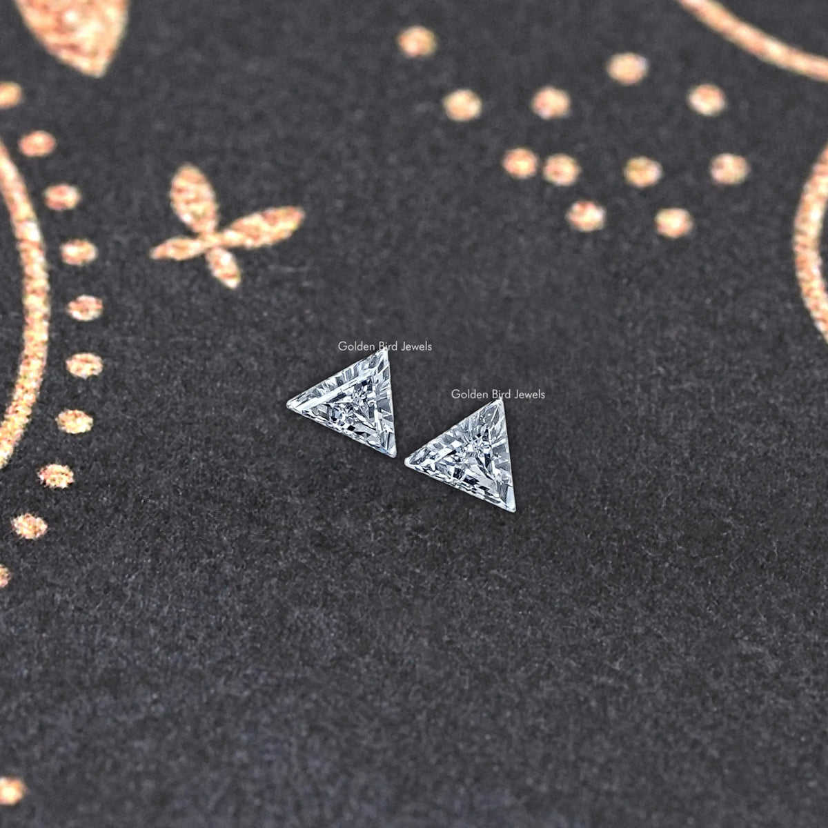 Two triangle lab-grown diamonds on dark felt, close-up centered