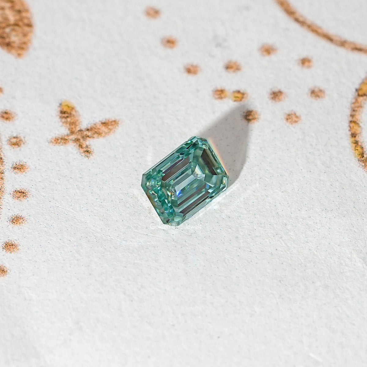 Emerald-cut green moissanite loose stone in a rotated perspective view