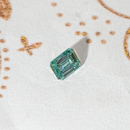 Emerald-cut green moissanite loose stone in a rotated perspective view