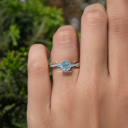 Aquamarine round-cut gemstone ring on finger with pave-set curved silver band