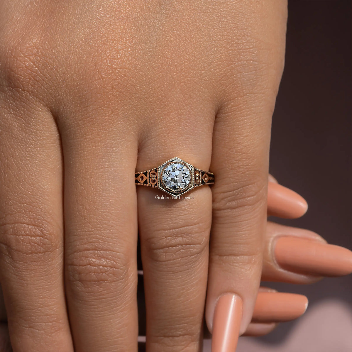 Diamond engagement ring on hand with ornate metalwork around the center stone