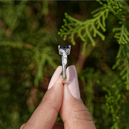 Black asscher-cut engagement ring viewed from the side, with prong-set sparkle stones