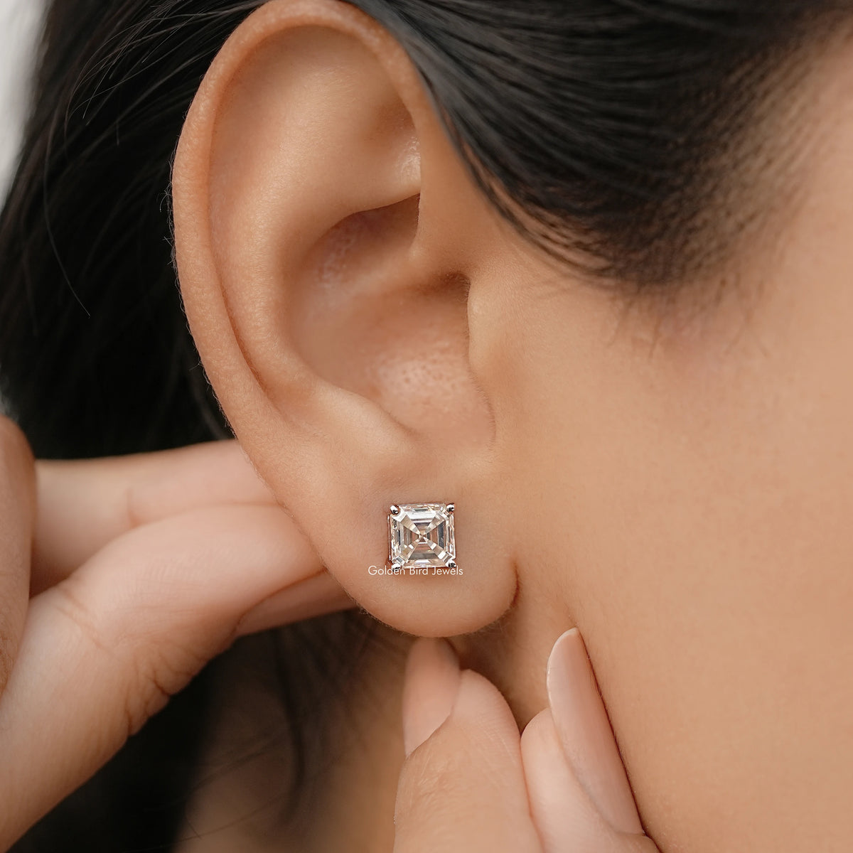 Asscher-cut moissanite stud earrings with square crystal setting in white gold.