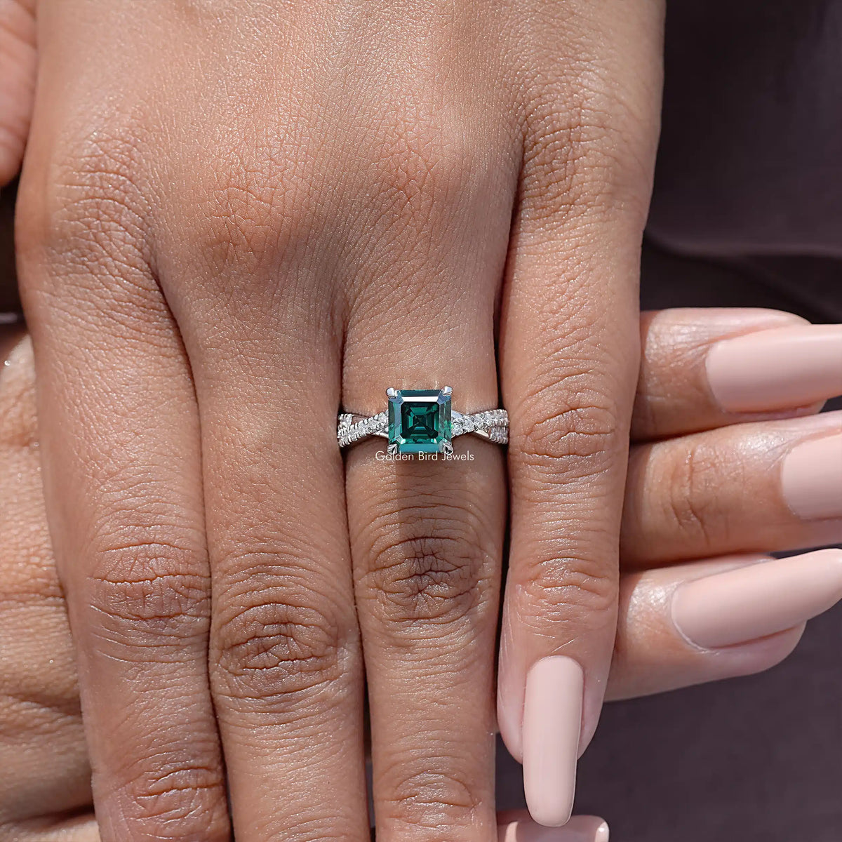 Close-up of sterling silver moissanite ring band with twisted accents and emerald-cut center