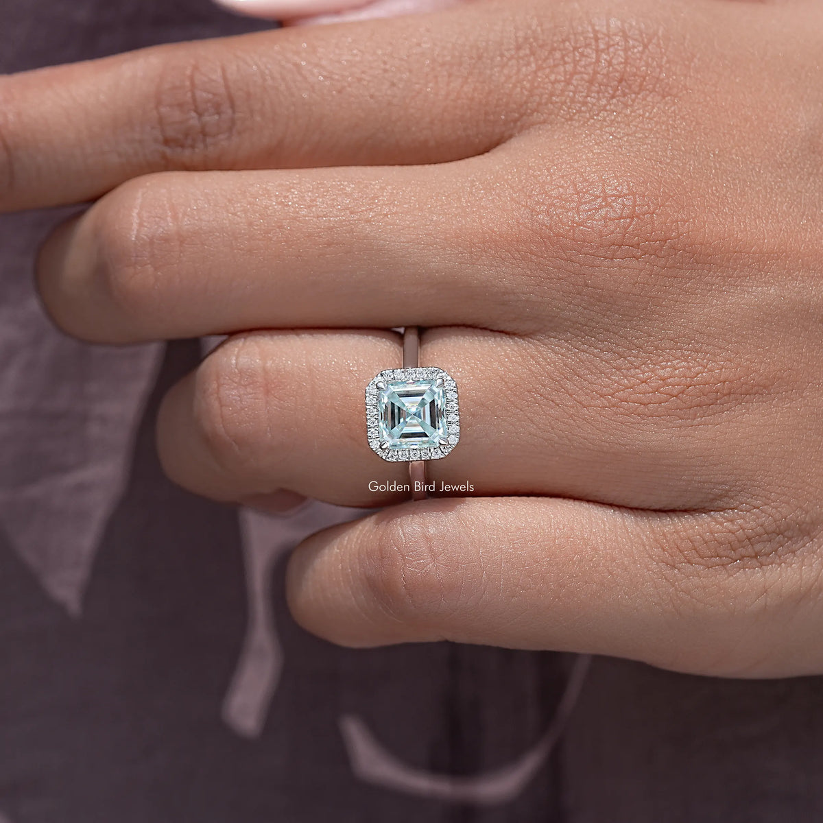 Asscher cut moissanite halo wedding ring close-up on fingers, prong-set square center