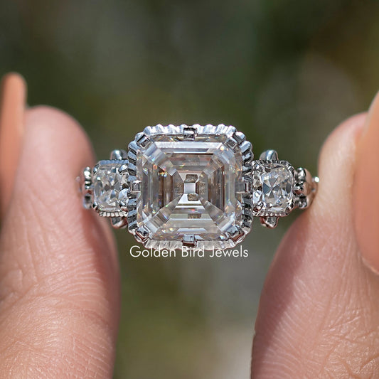 Three-stone moissanite ring with Asscher-cut center and prong-set side stones