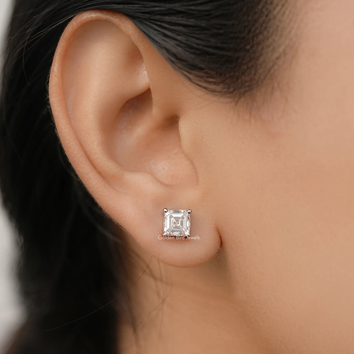 Asscher-cut moissanite stud earrings in white gold, square stone on post.