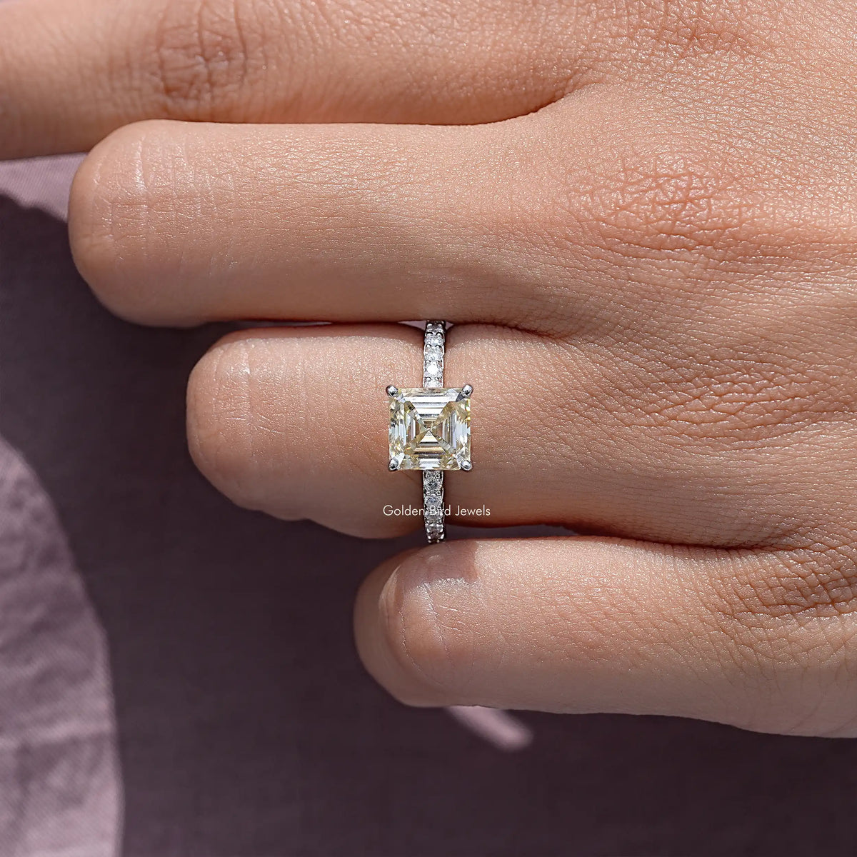 Sterling silver solitaire ring with rectangular asscher-cut gemstone on finger