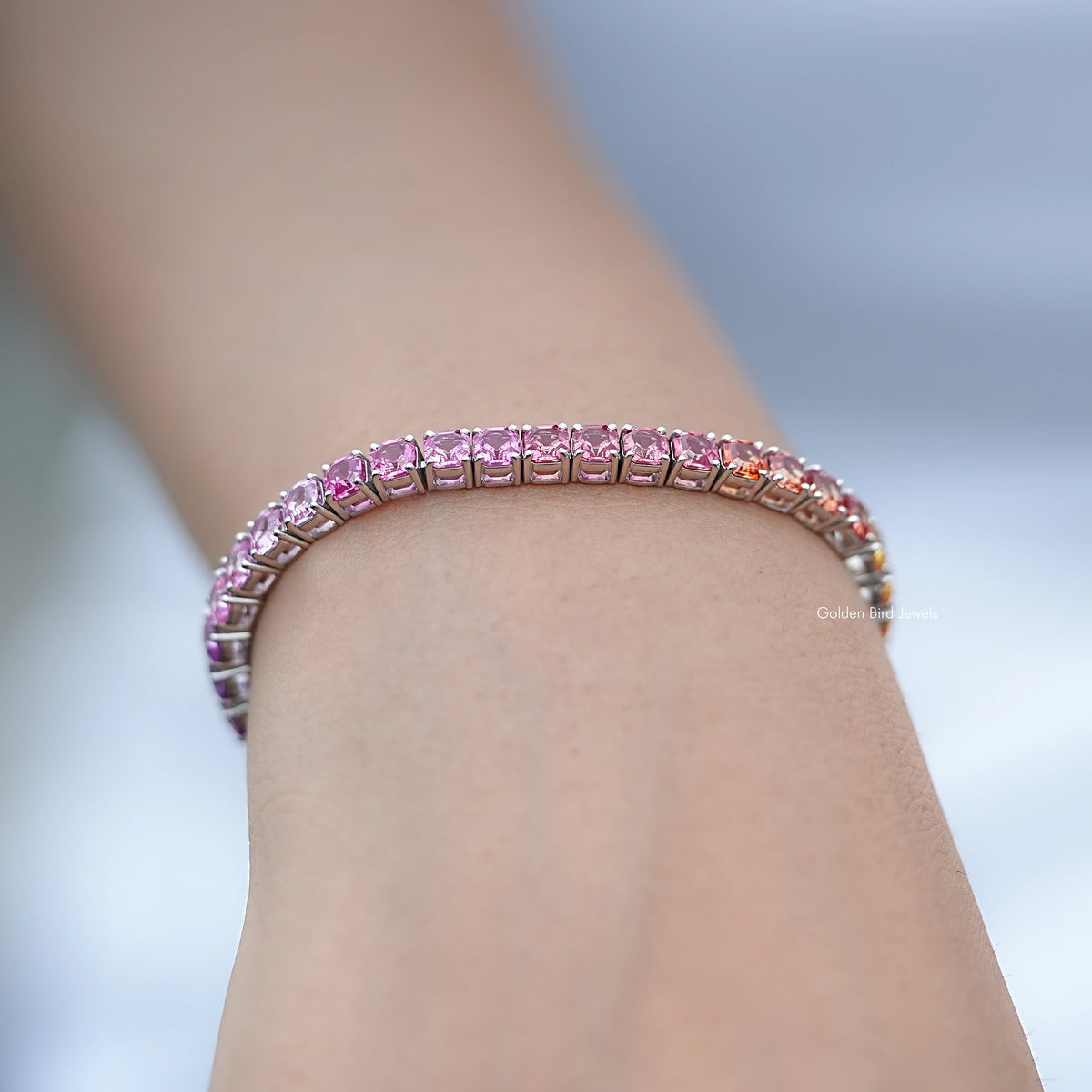 Close-up of tennis bracelet, purple gradient stones in silver bezel links.