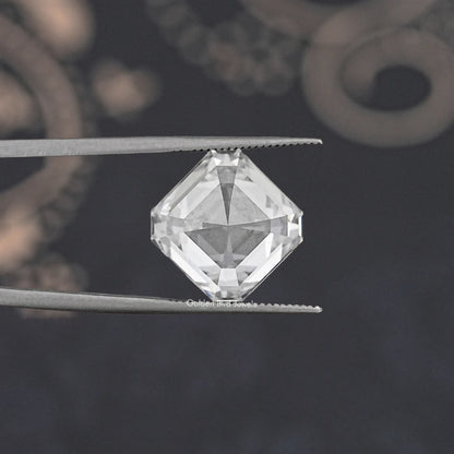 Asscher-cut lab-grown diamond viewed from above in tweezers, clear facets