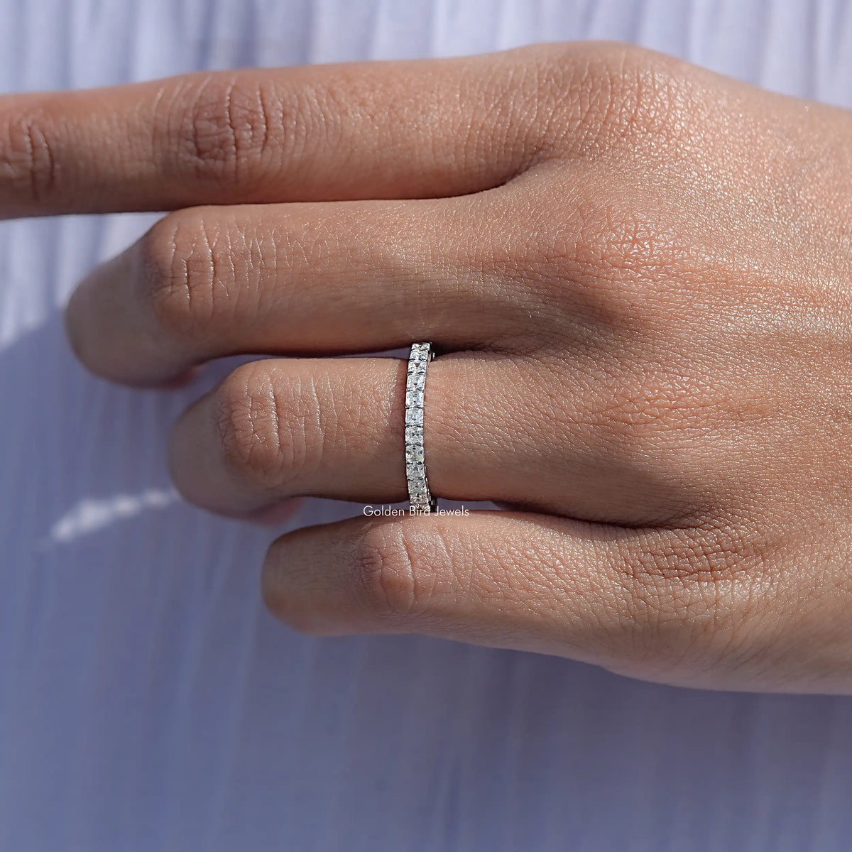18K white gold full eternity wedding band with square-cut stones on resting hand