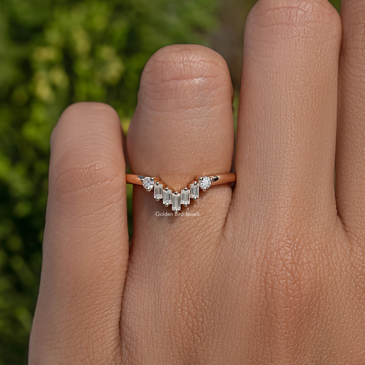 Curved wedding band ring with baguette-cut stones and small round accents, silver-tone