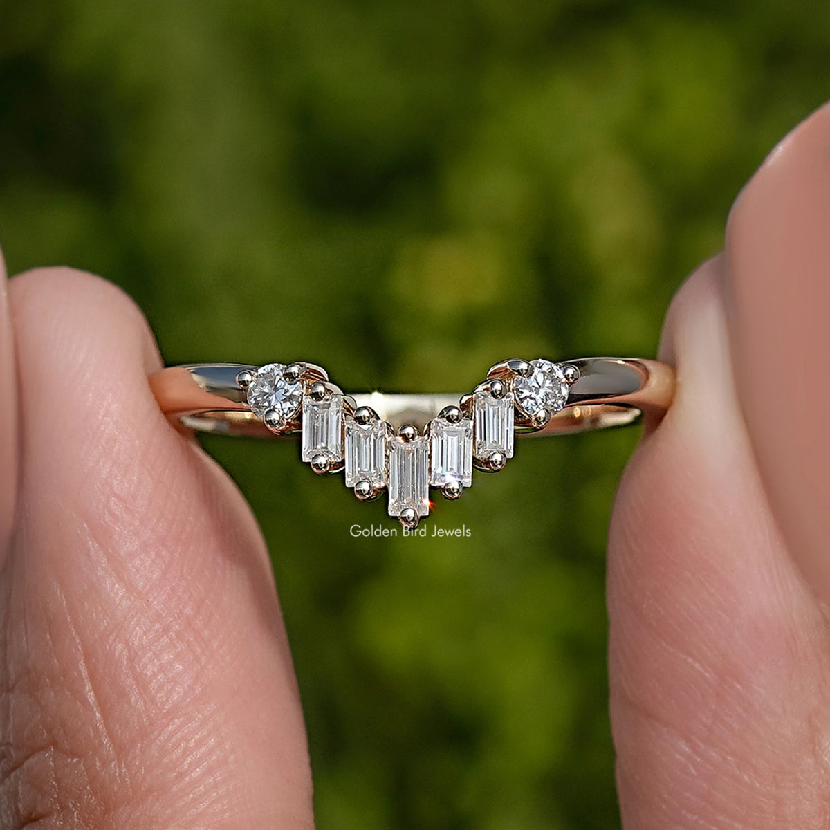 Curved wedding band ring with baguette-cut stones and small round accents, gold-tone metal