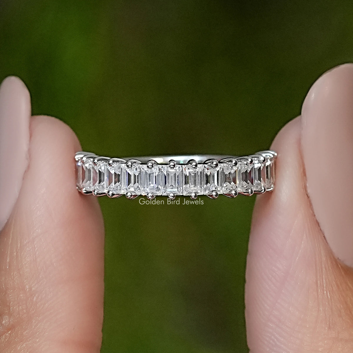 Silver ring with baguette-cut stones in a half-eternity band, close-up on hand