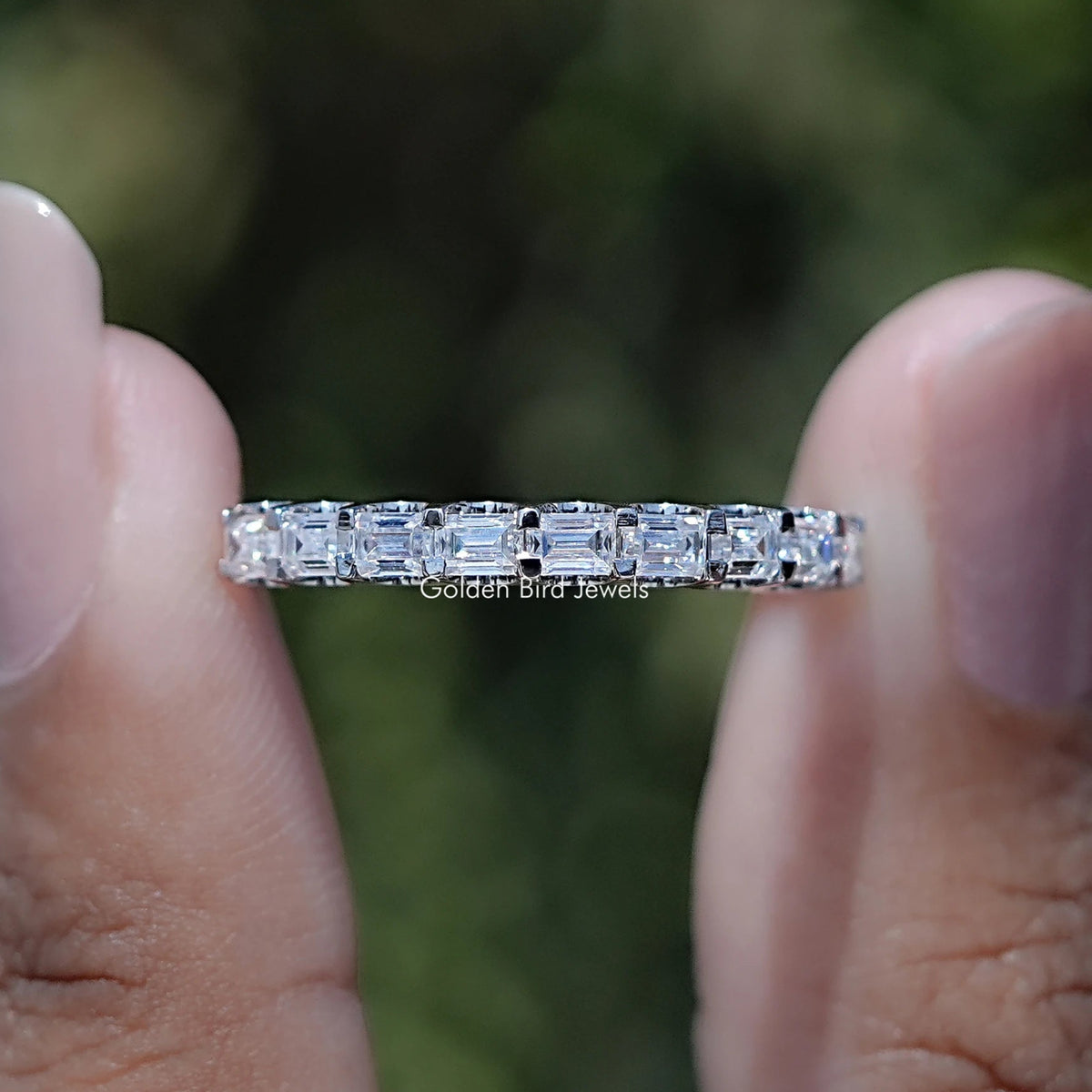 Close-up of baguette-cut moissanite stones on silver-toned half eternity band