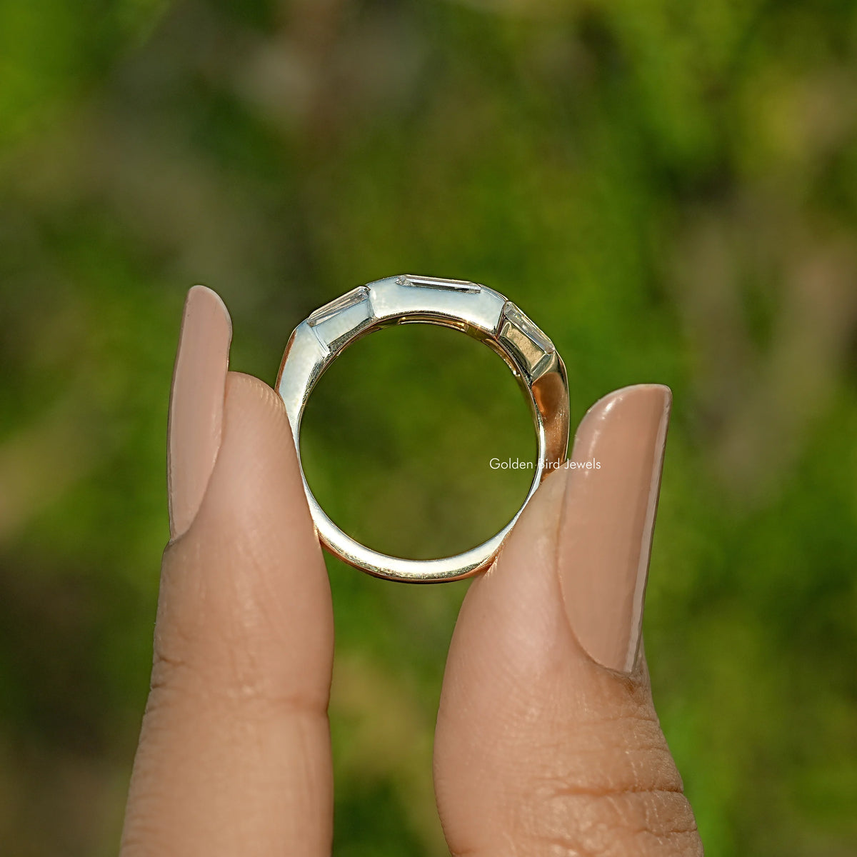 Three-stone baguette-cut moissanite ring with prong-set stones on a metal band