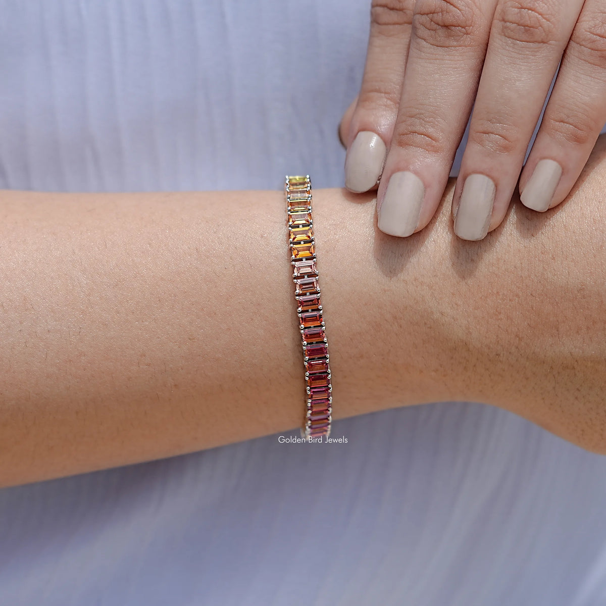 925 silver tennis bracelet with pink-red baguette gemstones, wrist close-up