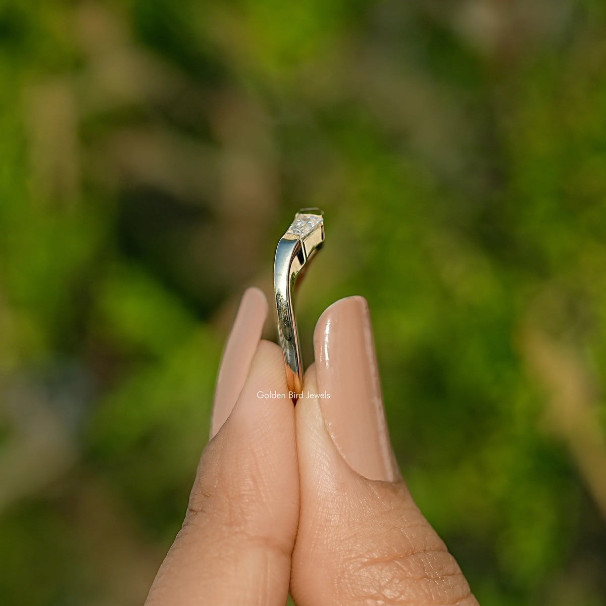 Side view of three-stone baguette-cut moissanite ring with raised prongs